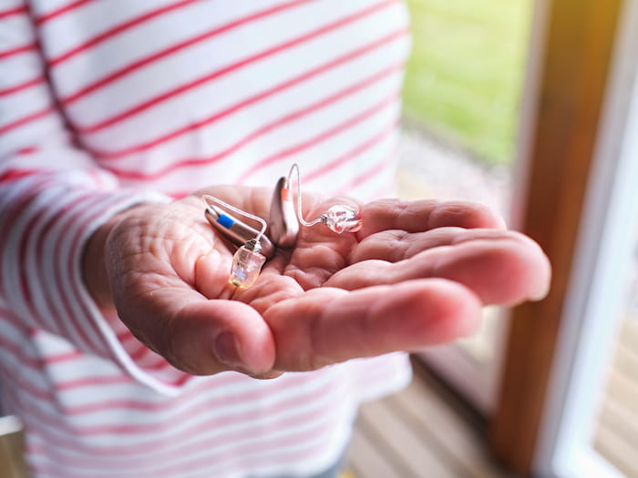 Person with hearing aids on hand